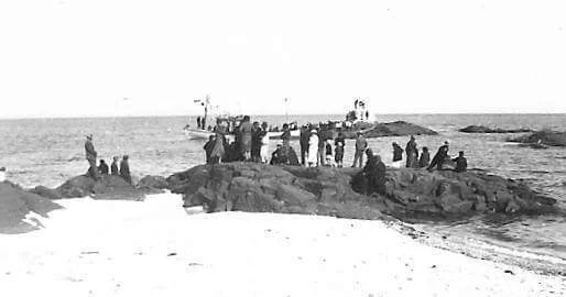 Families gathered on rocks by the sea