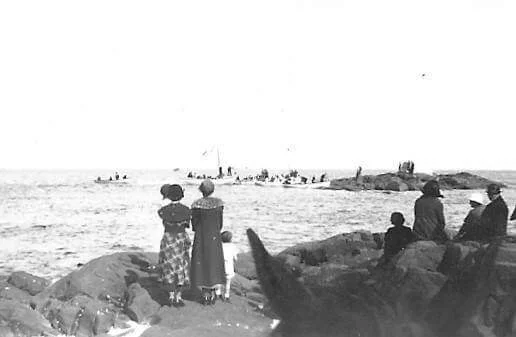 Residents watch a gathering on the rocks