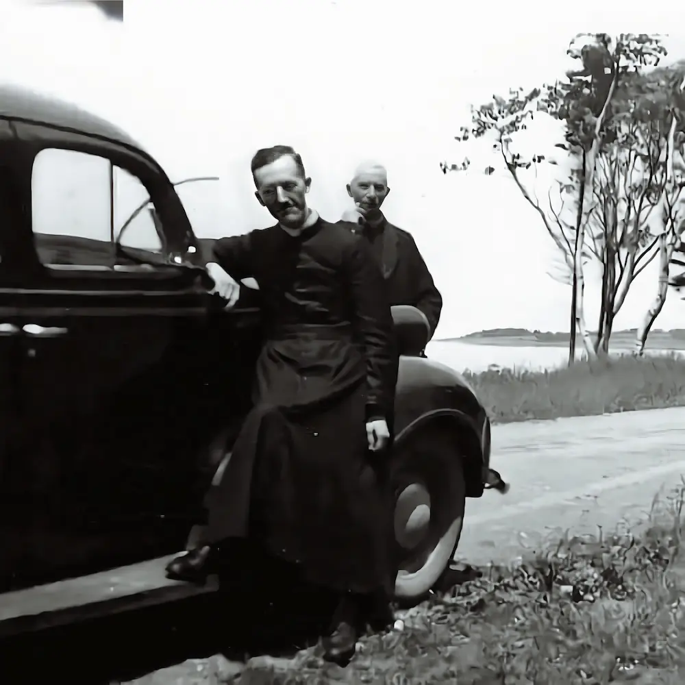 Padre Basile Babin e un confratello accanto a un’automobile d’epoca