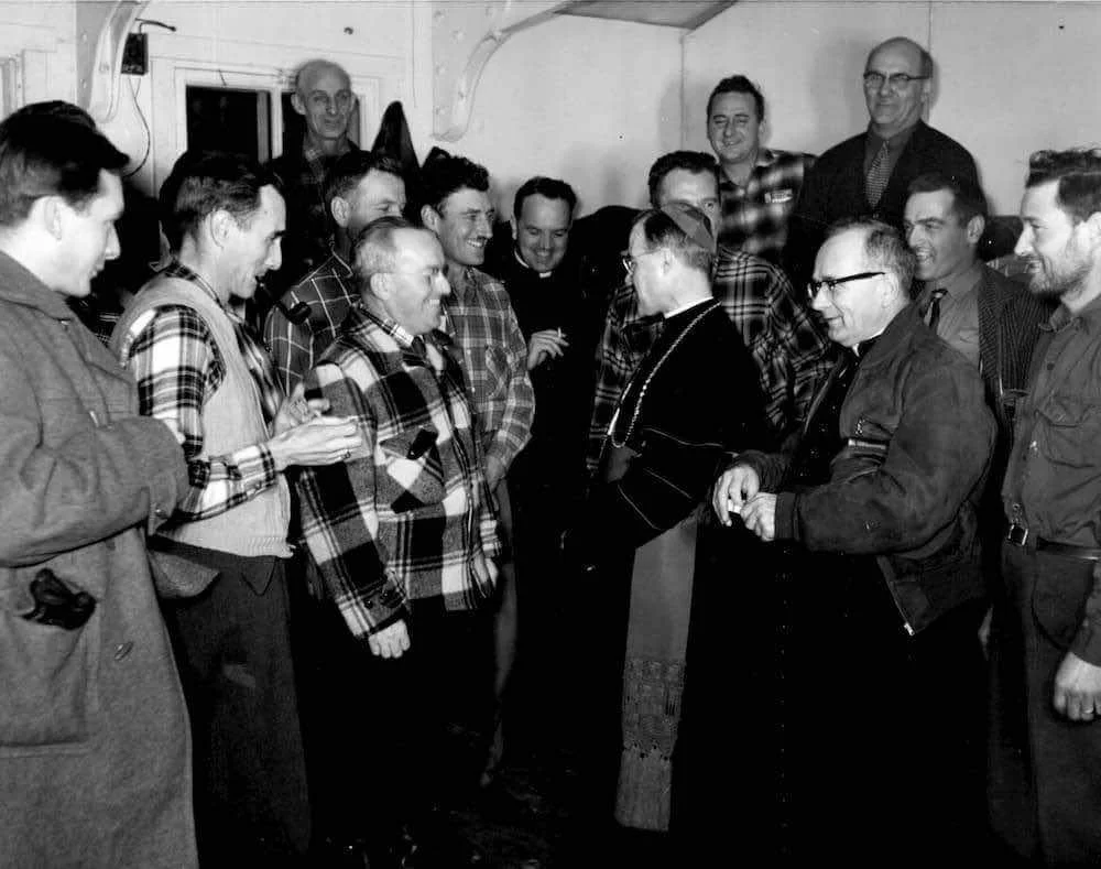 Bishop Couturier speaks with a group of workers