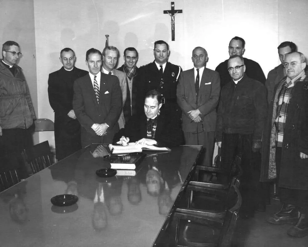 Bishop Couturier and visitors gathered around a table
